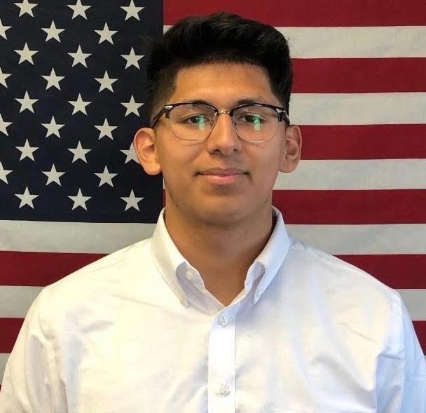 Specialist Alejandro Lee Puckett in front of the American flag